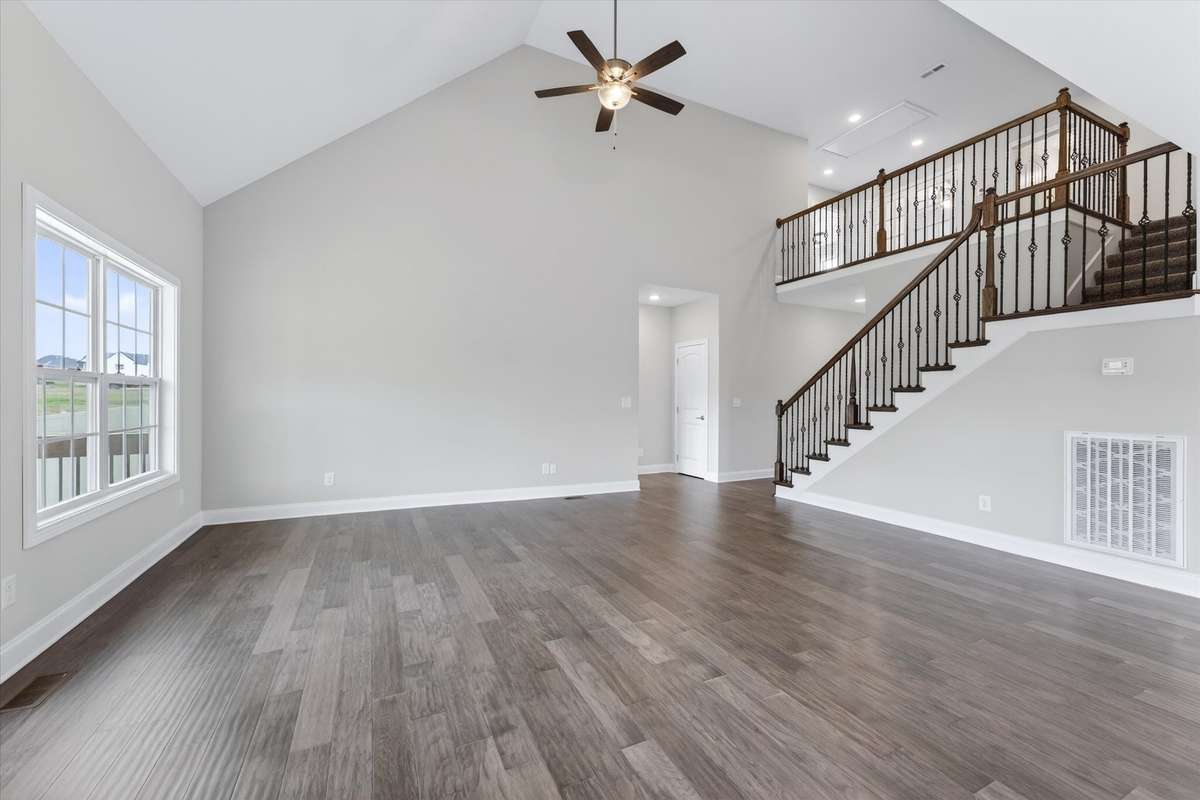 Spacious living area with open staircase and seamless layout