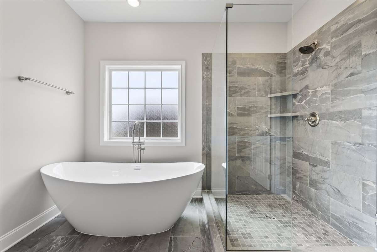 Luxury en suite bath with freestanding soaking tub and tiled walk-in shower