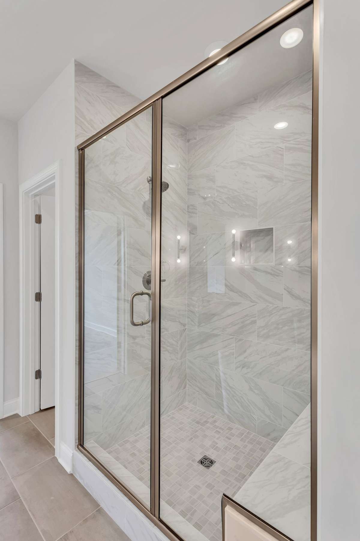 shower with tile to the ceiling with a bench