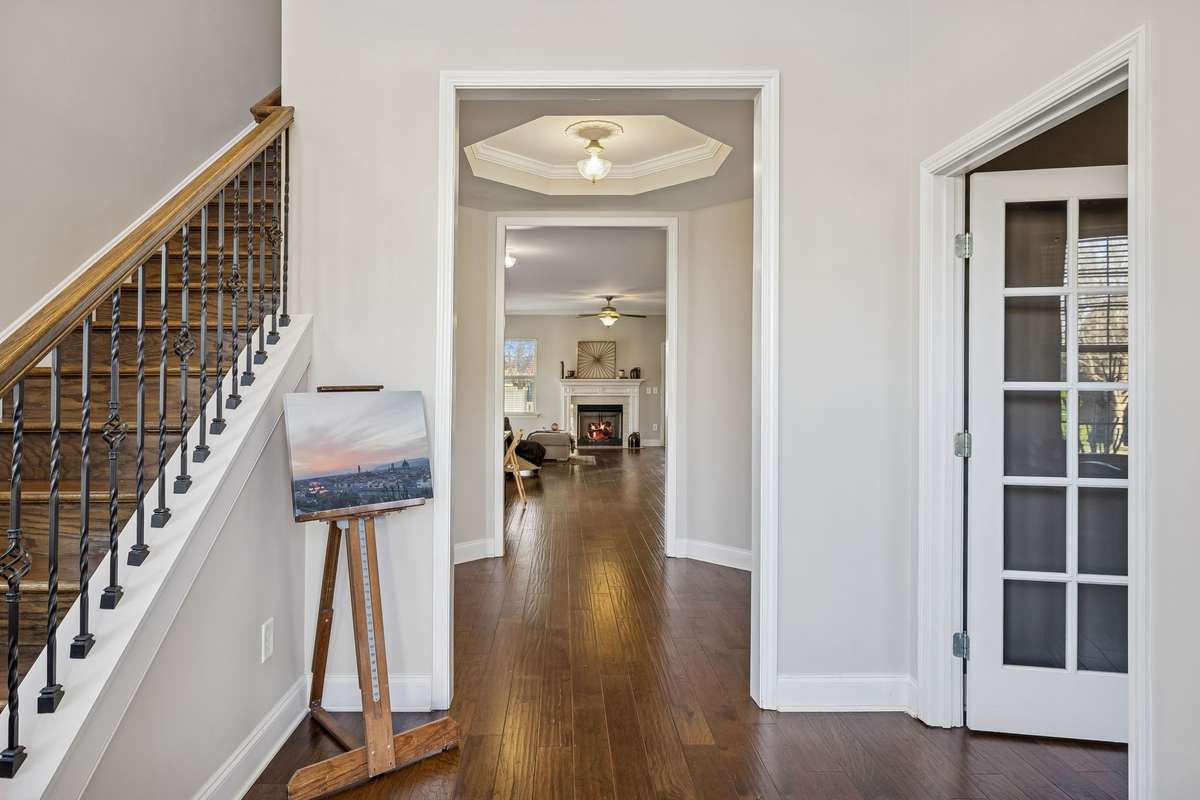 As we walk into the front door, we are greeted with a large foyer. The stairs lead upstairs to 3 bedrooms, 2 baths, and a large bonus room.  This home has 2 primary bedrooms.
The door to the right leads to an office or the 5th bedroom