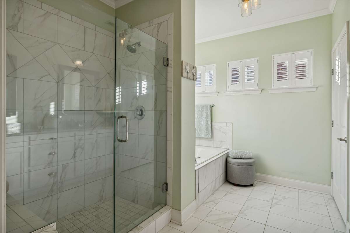 Primary bath with granite countertops, jetted tub, and walk-in shower.