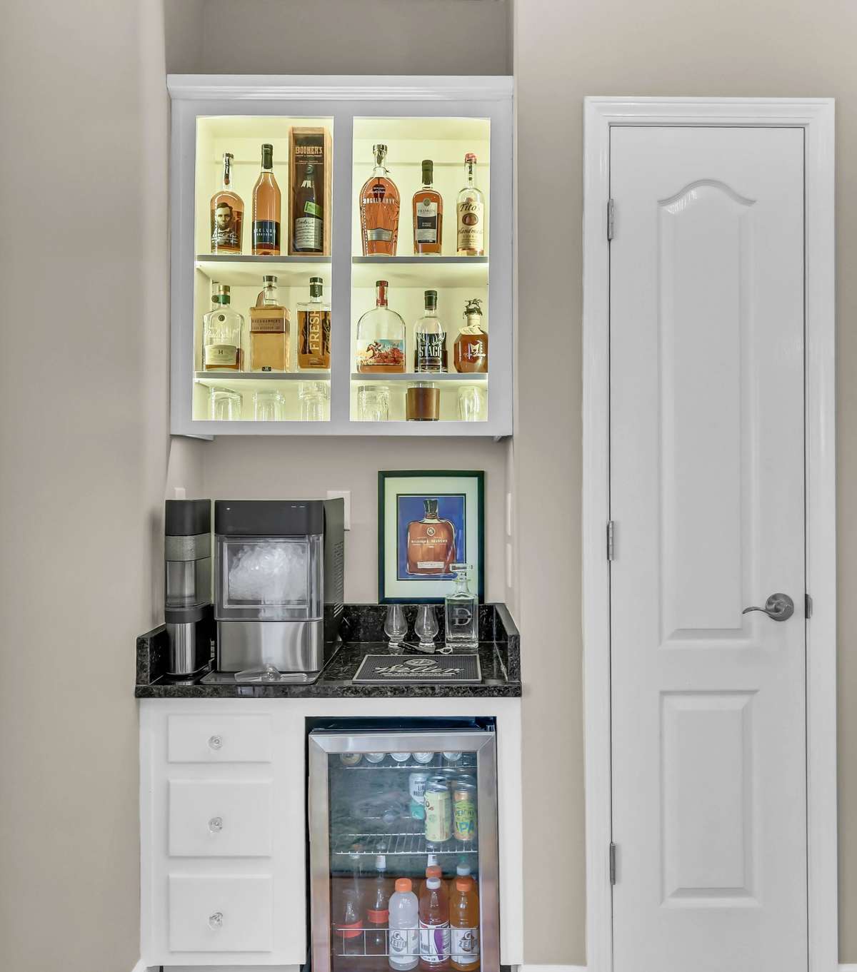 The bar area includes a mini fridge + granite counters + cabinet lighting!