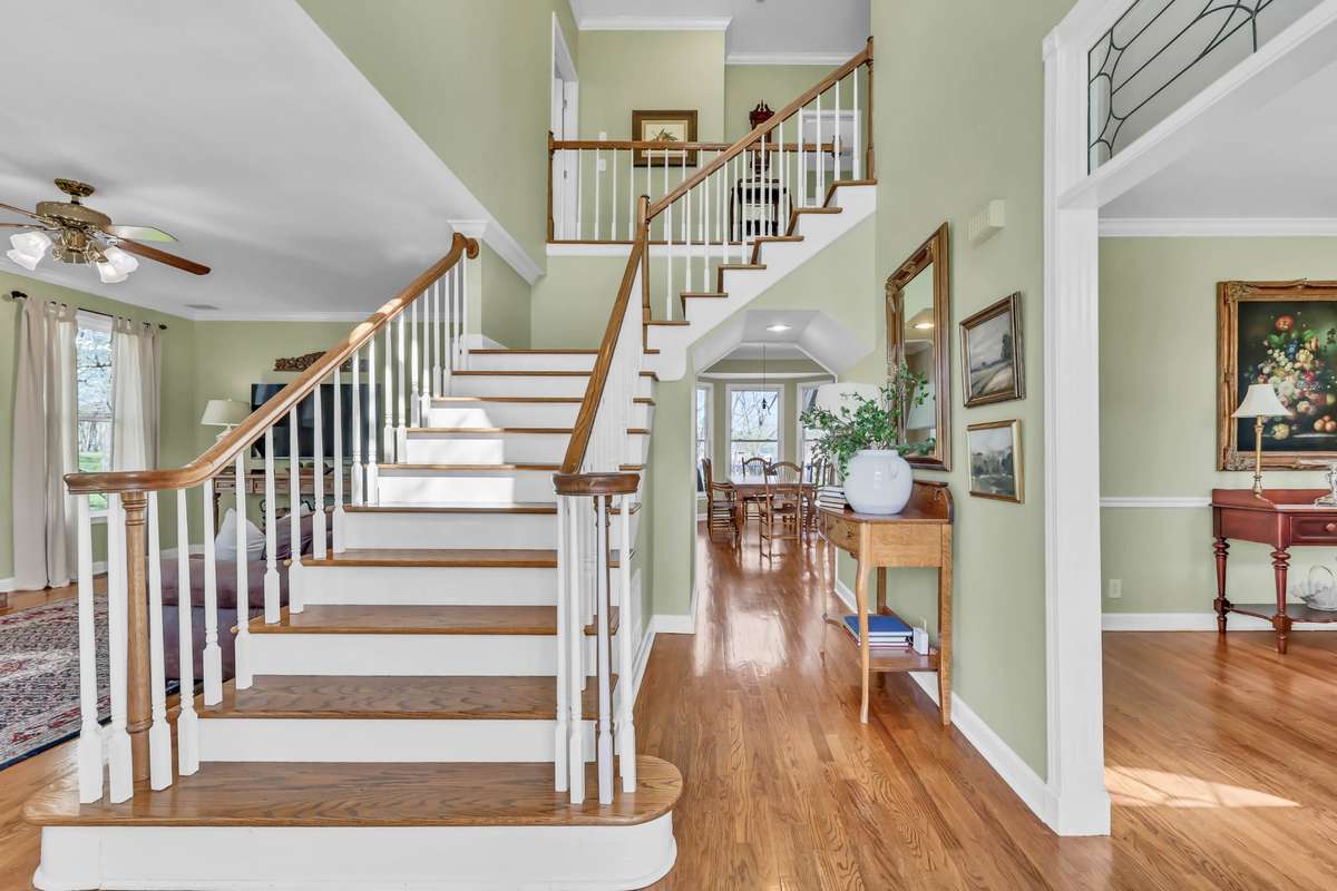 Step inside to soaring entry foyer with rich hardwood & elegant glass-paneled doorways