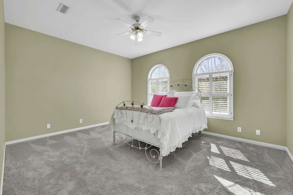 Bedroom 2 with plush carpet + plantation shudders + arched windows