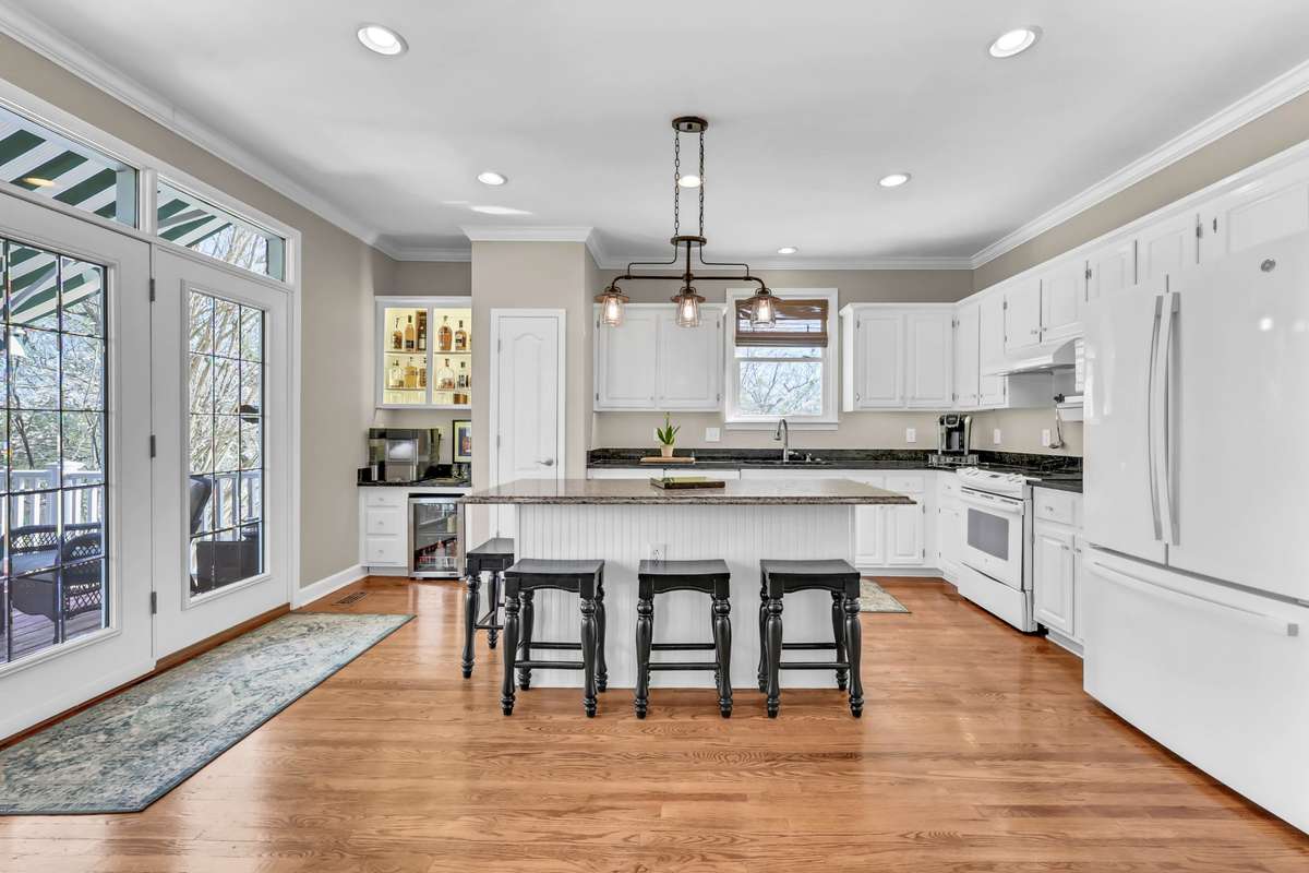 The open kitchen is bright + white with plenty of cabinet & counter space