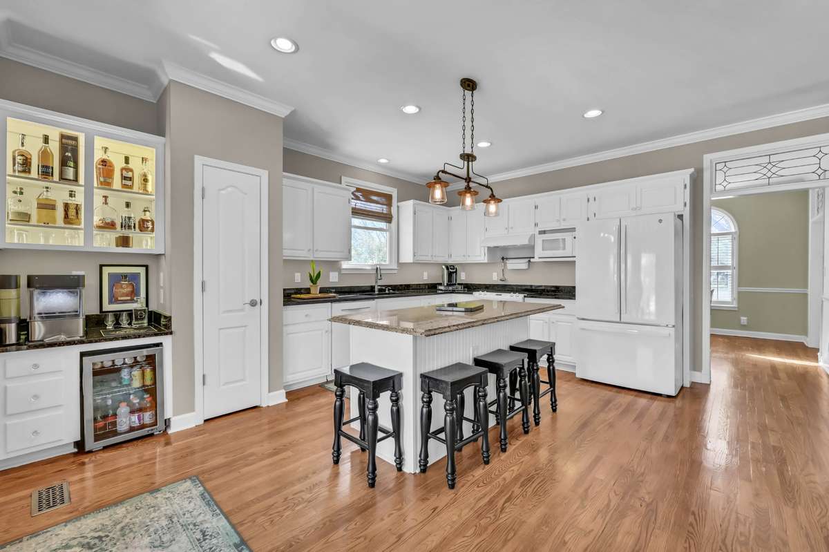 The kitchen features a generous island + updated lighting + granite counters + pantry + wet bar
