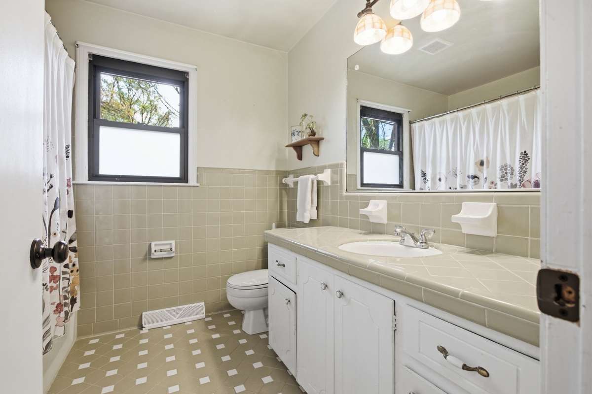 Main bath located in hall leading to bedrooms.