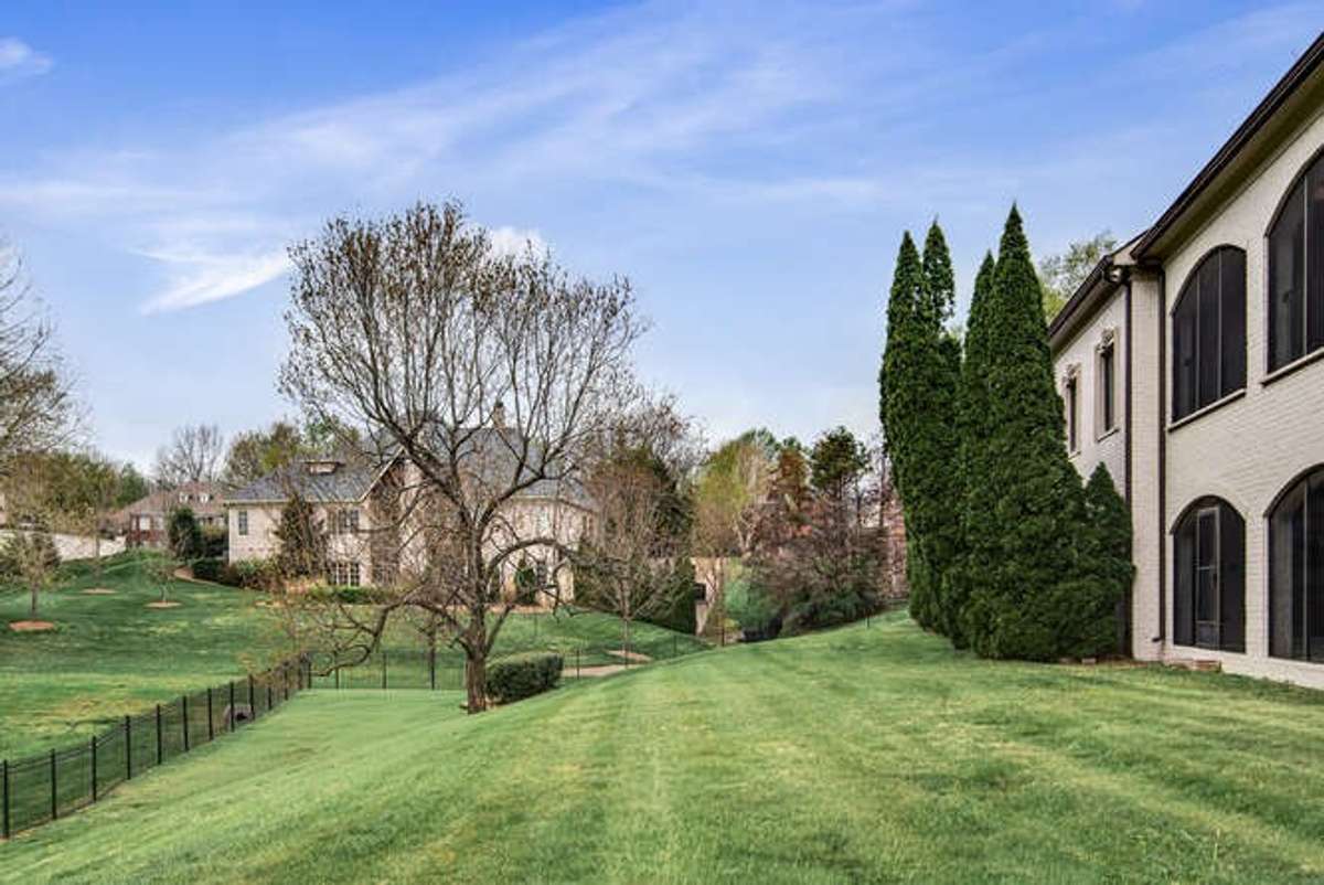 Fully fenced backyard looks out to common area.