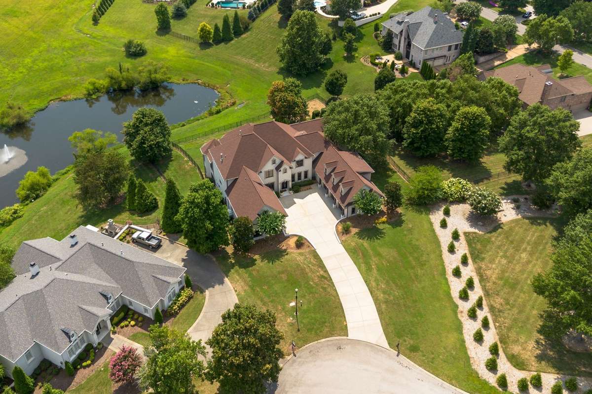 Aerial view shows the pond and the large common area behind this home.