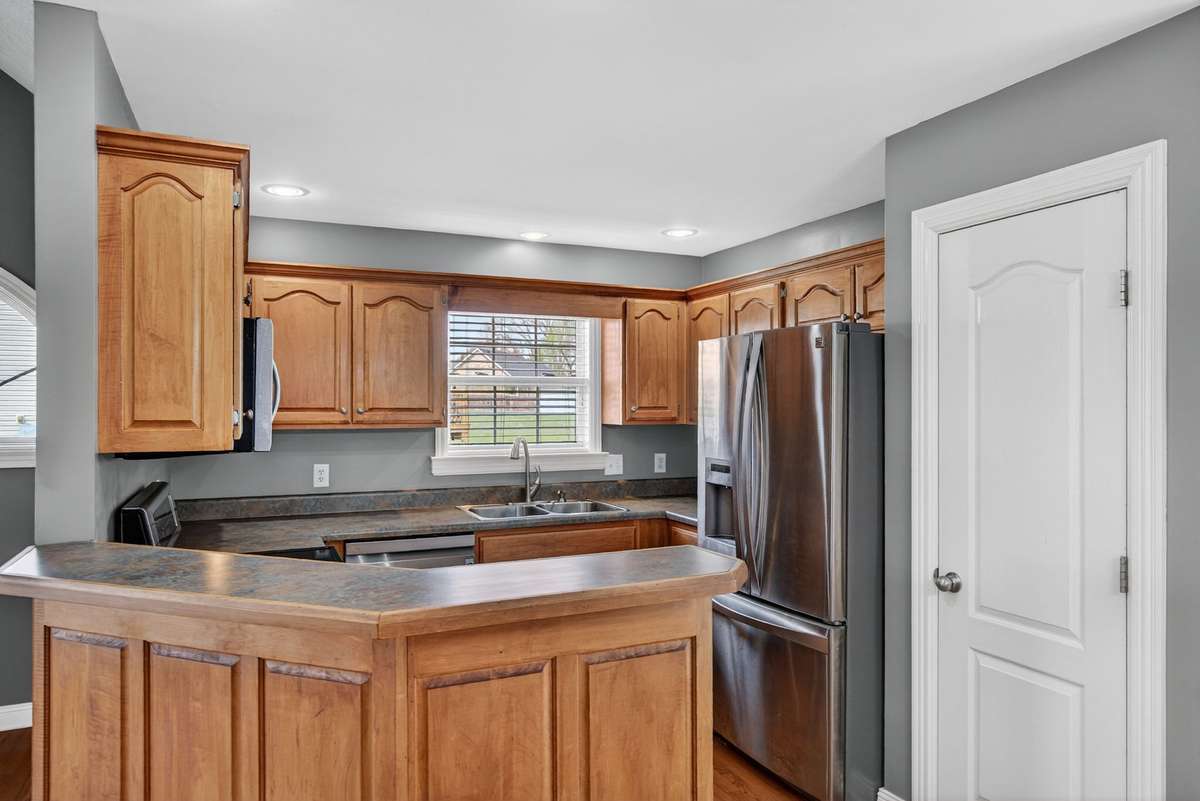 Kitchen features a pantry, bar seating, and stainless appliances.