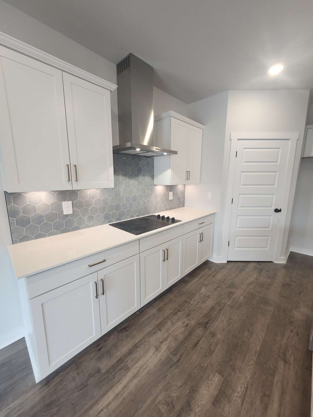 Under cabinet lighting and tile backsplash, with hood vent and cooktop