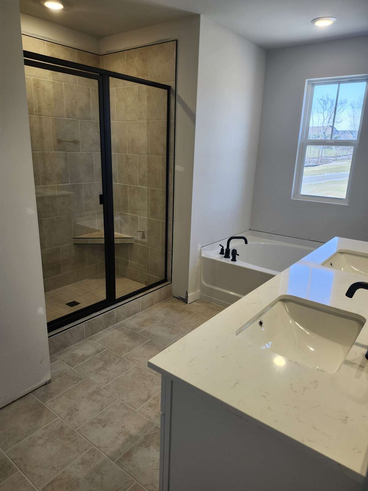 Primary bathroom with tile shower and garden tub