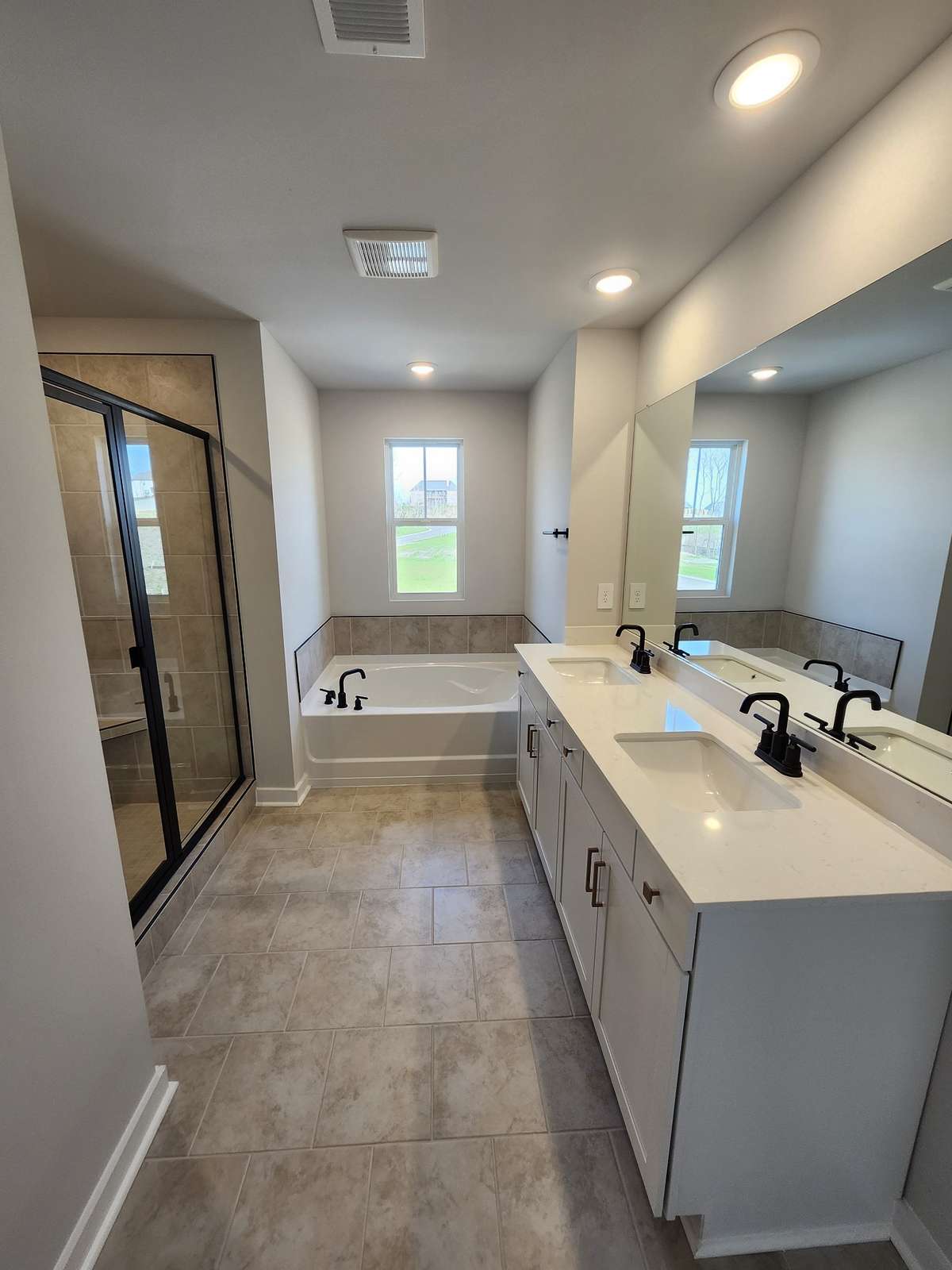 Primary bathroom with tile shower and garden tub