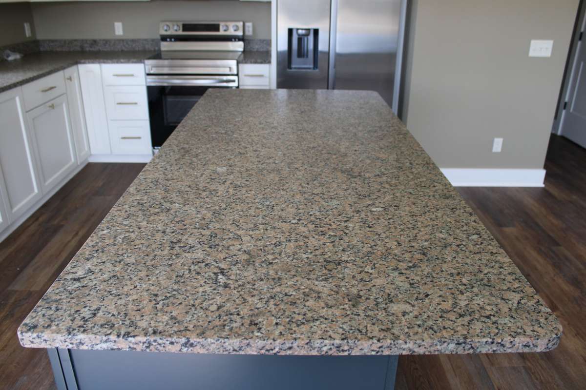 Leather finished quartz on Island which is large enough for four bar stools to dine.