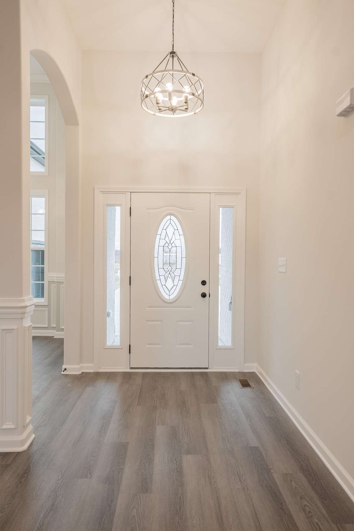 Large Entry Foyer with Wood Flooring, Crown Molding and an Elegant Chandelier!
