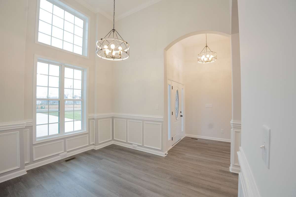 Spacious Formal Dining Room with Wainscoting, 14' High Ceiling, Crown Molding, Elegant Archways and Tons of Natural Light!