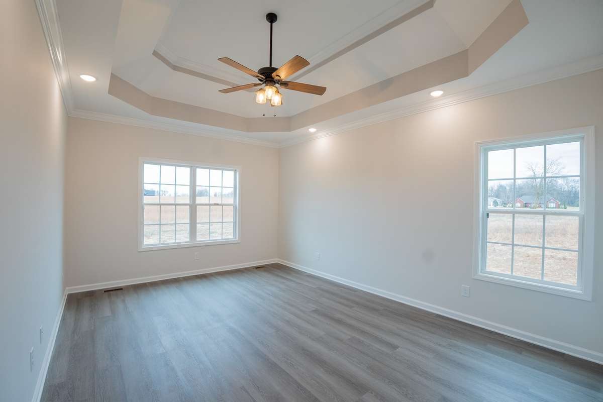 Spacious Primary Bedroom Features a Double Tray Ceiling, Crown Molding and Recessed Lighting!