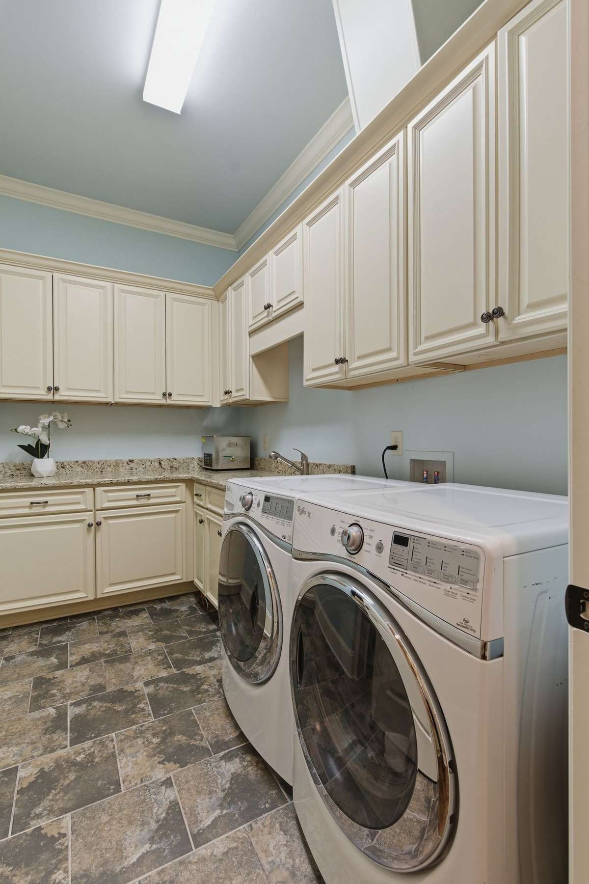 Great laundry room with nice space to keep everything hidden. There’s also a laundry shoot in the cabinet above the dryer.
