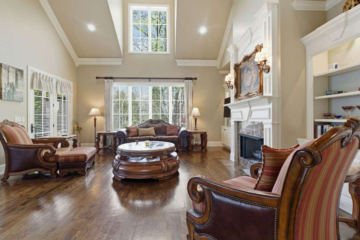 Great room exemplifies high ceilings, natural sunlight, built-in shelving, and gas fireplace.