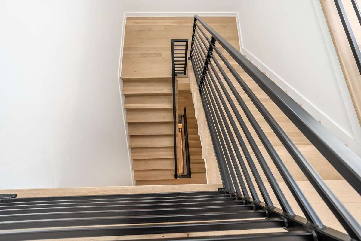 Stairs down one floor to the private owner's level with primary bedroom suite and private office