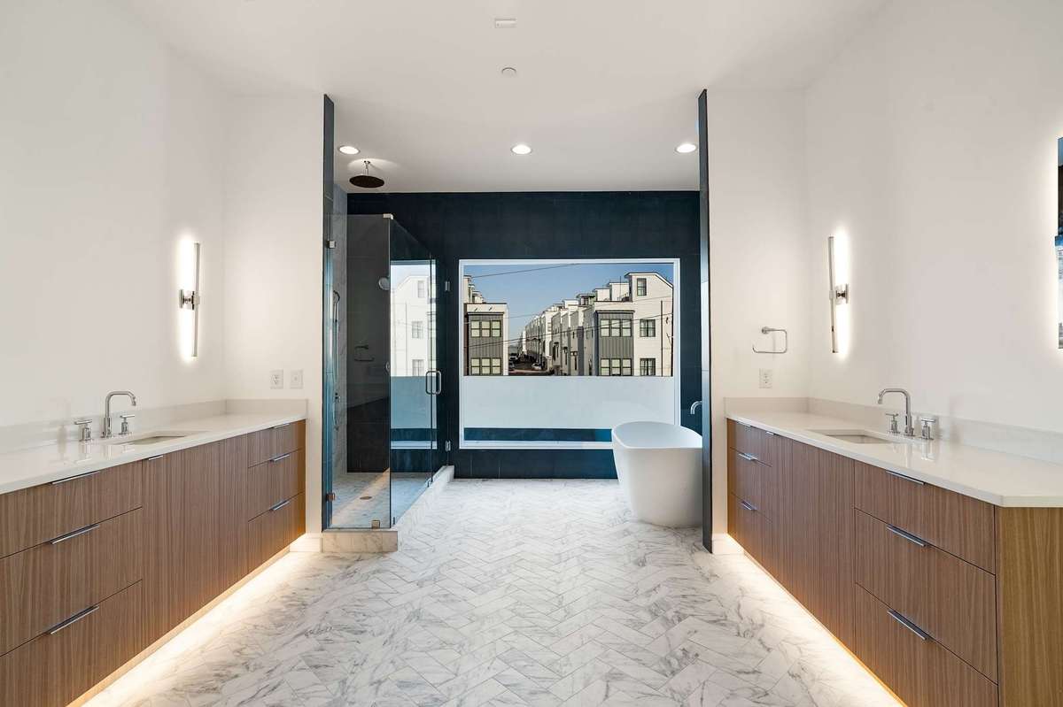 One floor down, primary bath highlights the owners level