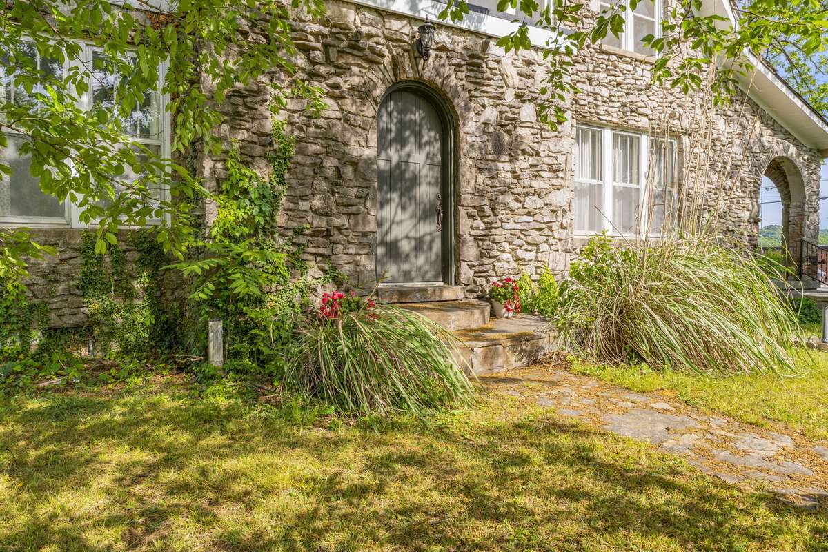 Native grasses and trailing ivy adorn the front of the home.