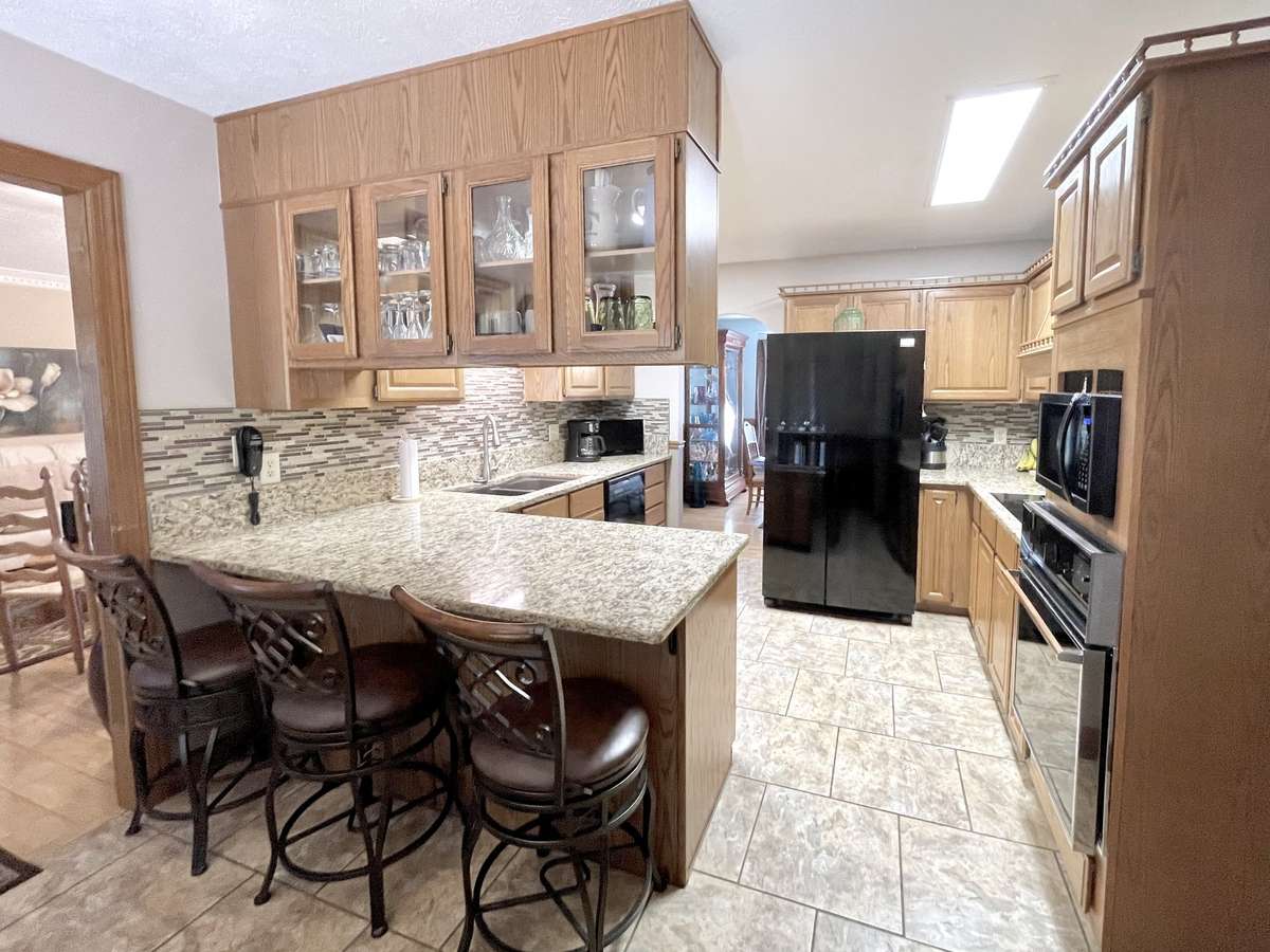 Granite Counter, Modern Tile Backsplash & Tile Flooring in Kitchen. All Appliances Remain.
