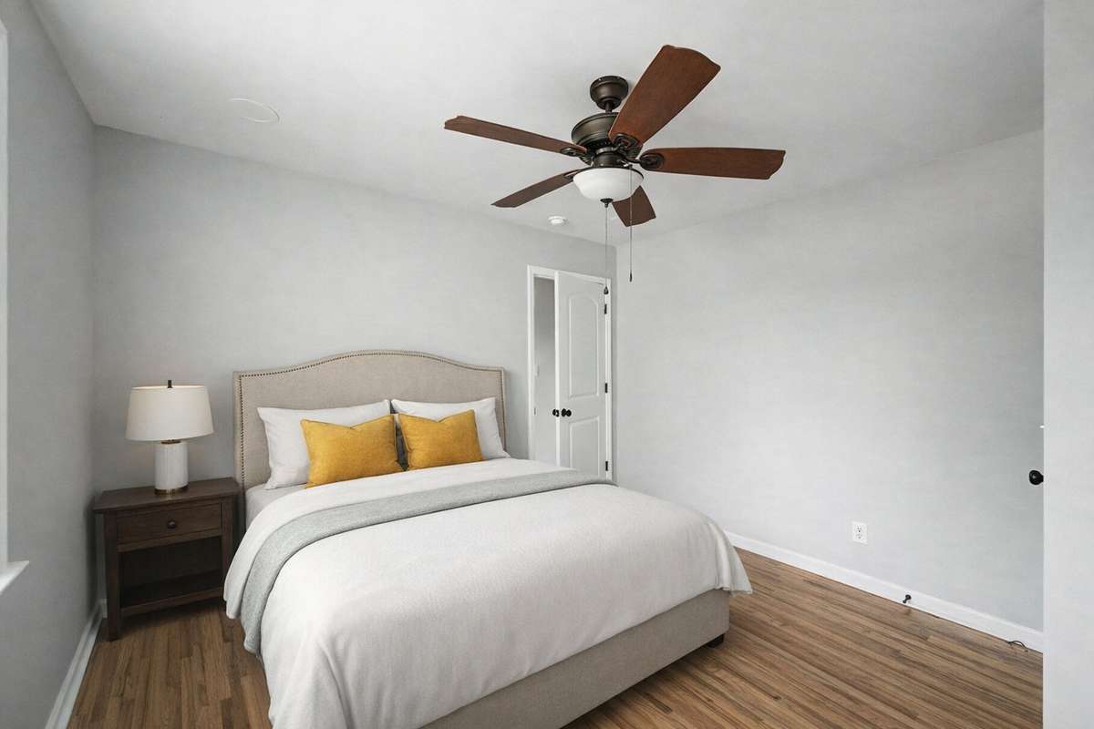 This bedroom has new floors, fresh paint and a new ceiling fan.