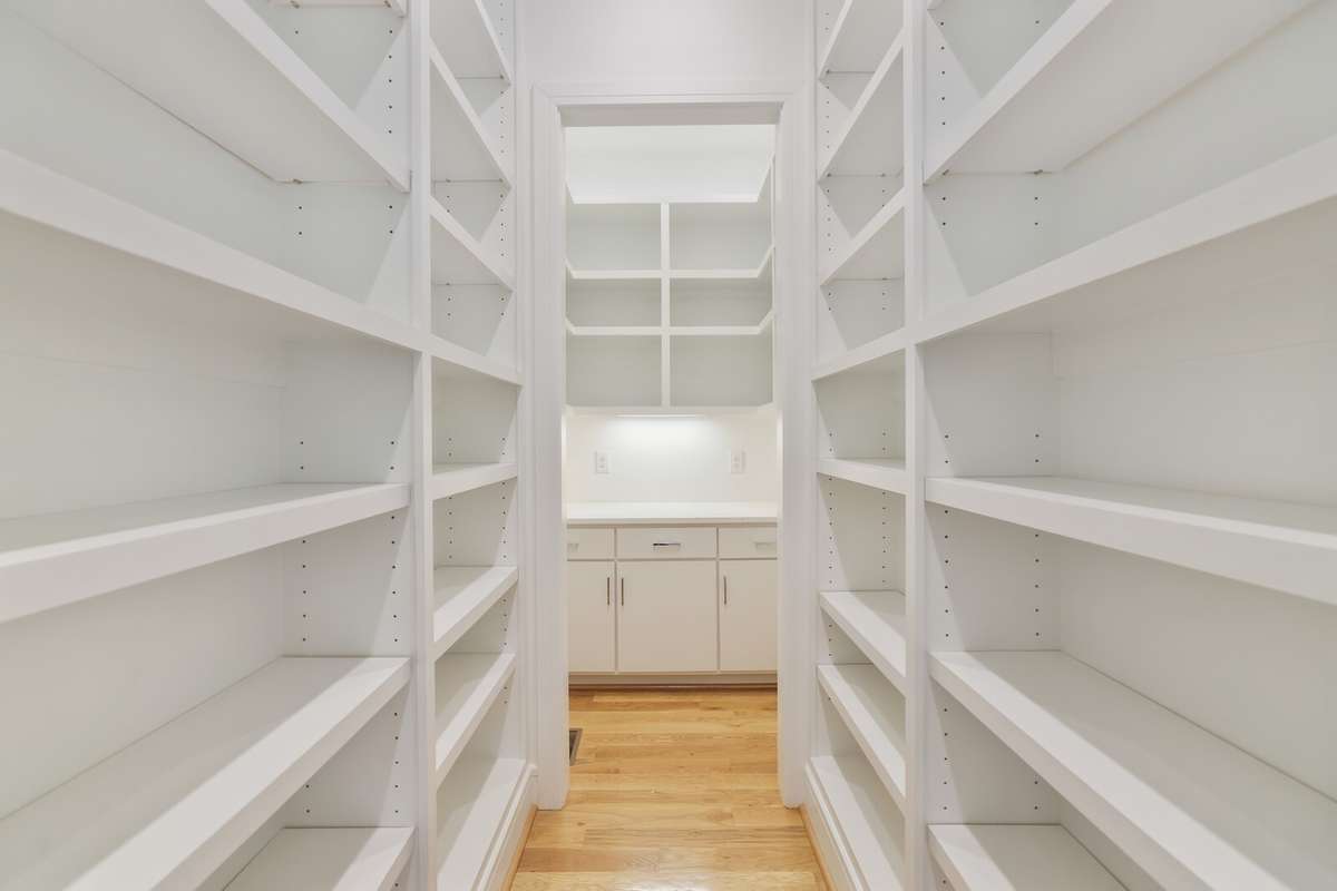 Huge walk in pantry off kitchen has shelving on both sides.