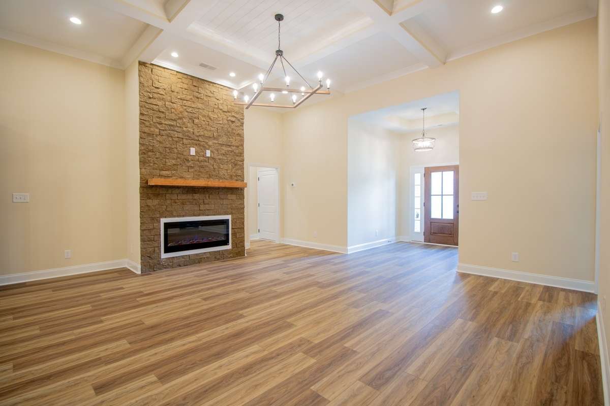 EXAMPLE>>>Large Living Room Features an Electric Fireplace with a Floating Wood Mantle and a Coffered Ceiling!