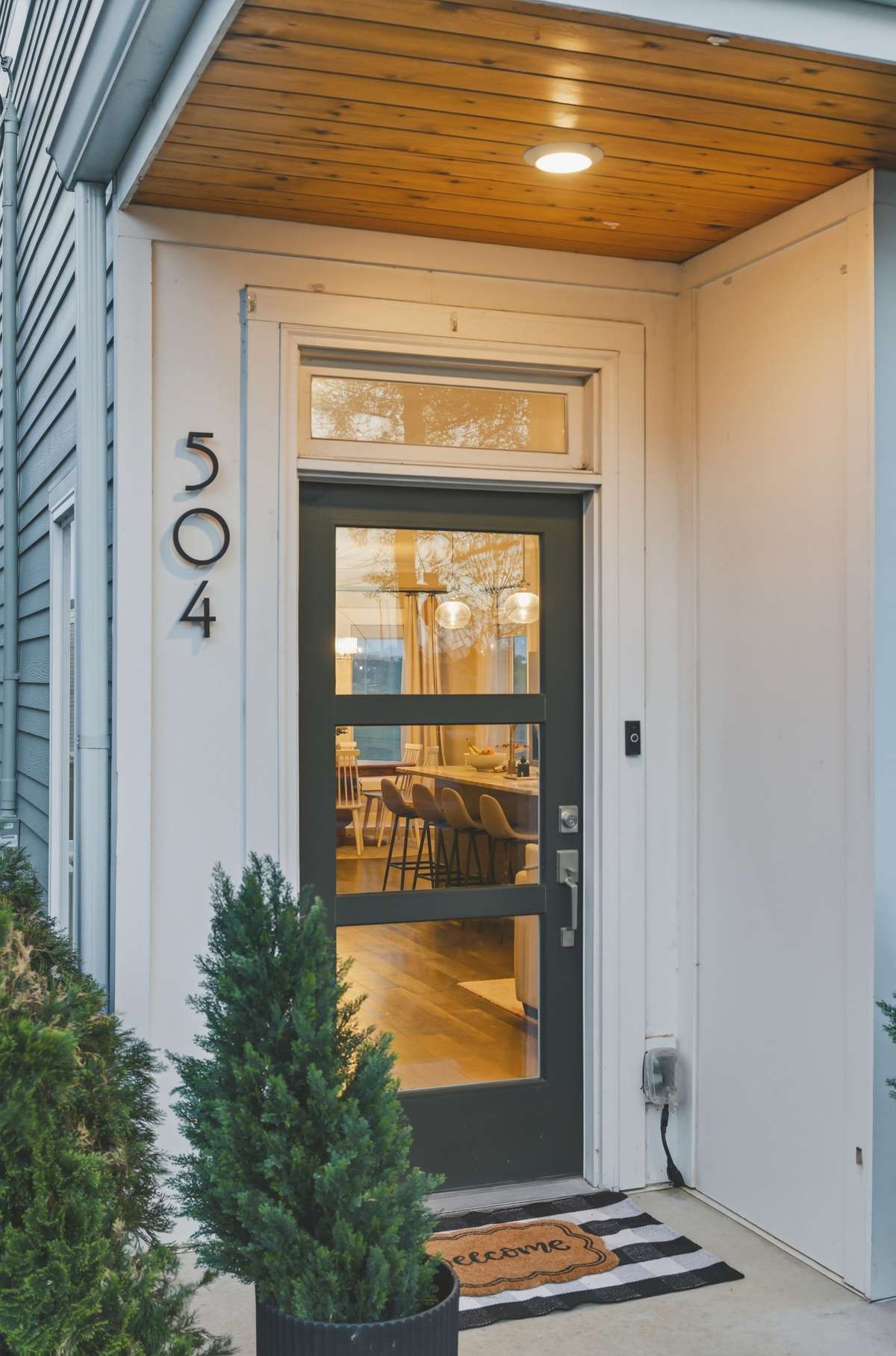 Attractive landscaping and shiplap accents frame the front door.