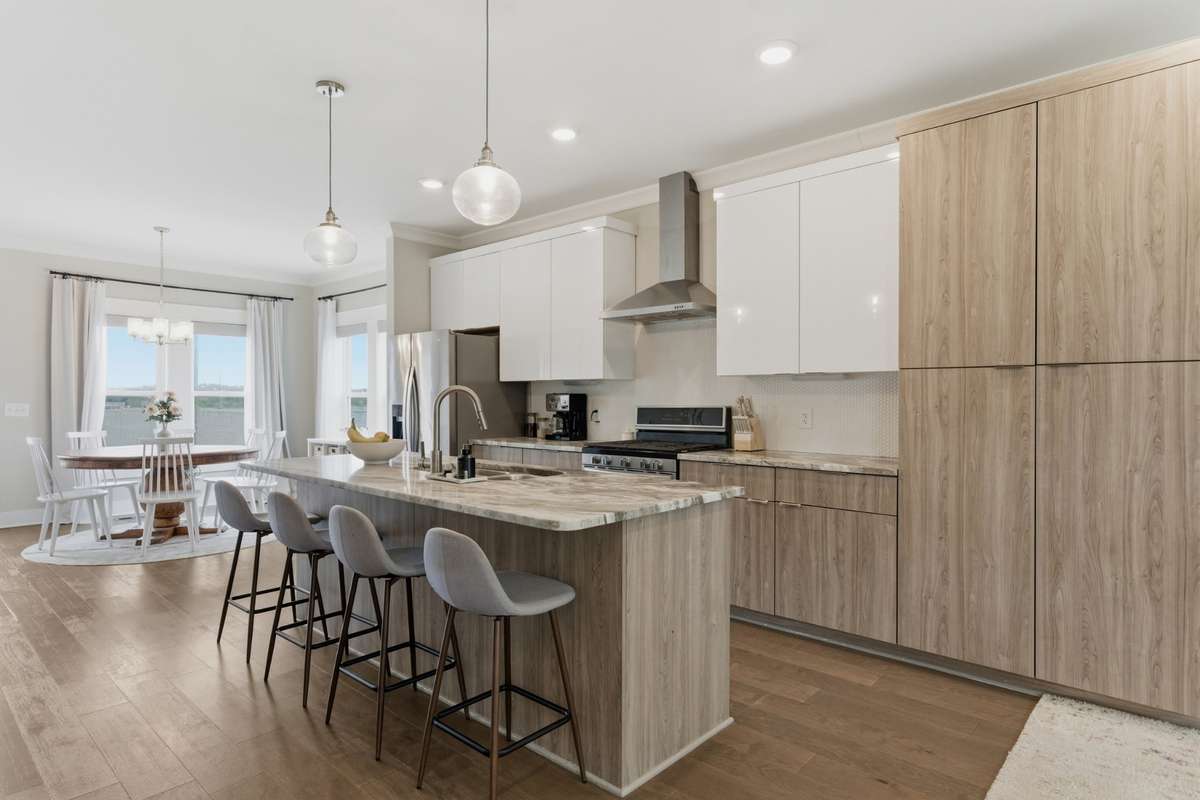 The modern kitchen features warm, neutral tones. A tall built-in pantry adds plenty of storage.