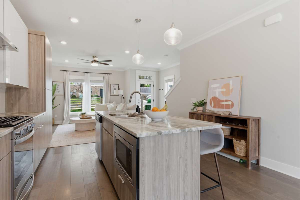 Elegant pendant lights illuminate the wide breakfast bar.