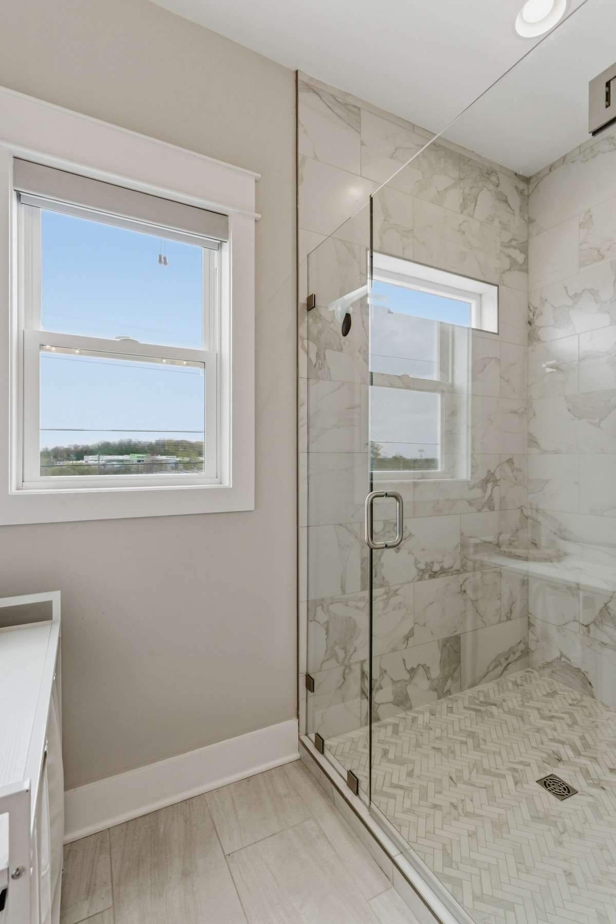 The custom walk-in shower is tucked into a sunlit alcove.