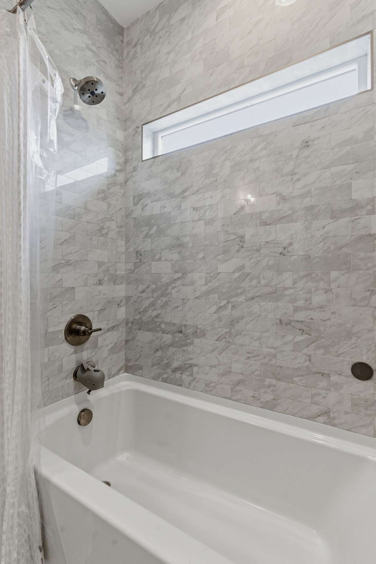 This one features a deep bathtub with an elegant tile surround and a custom window cutout.
