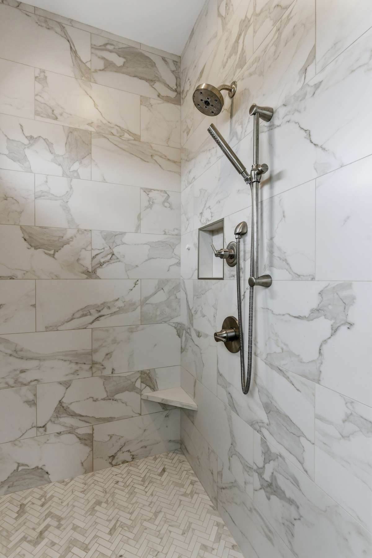 It features an upgraded dual shower head and gorgeous tile finishes.