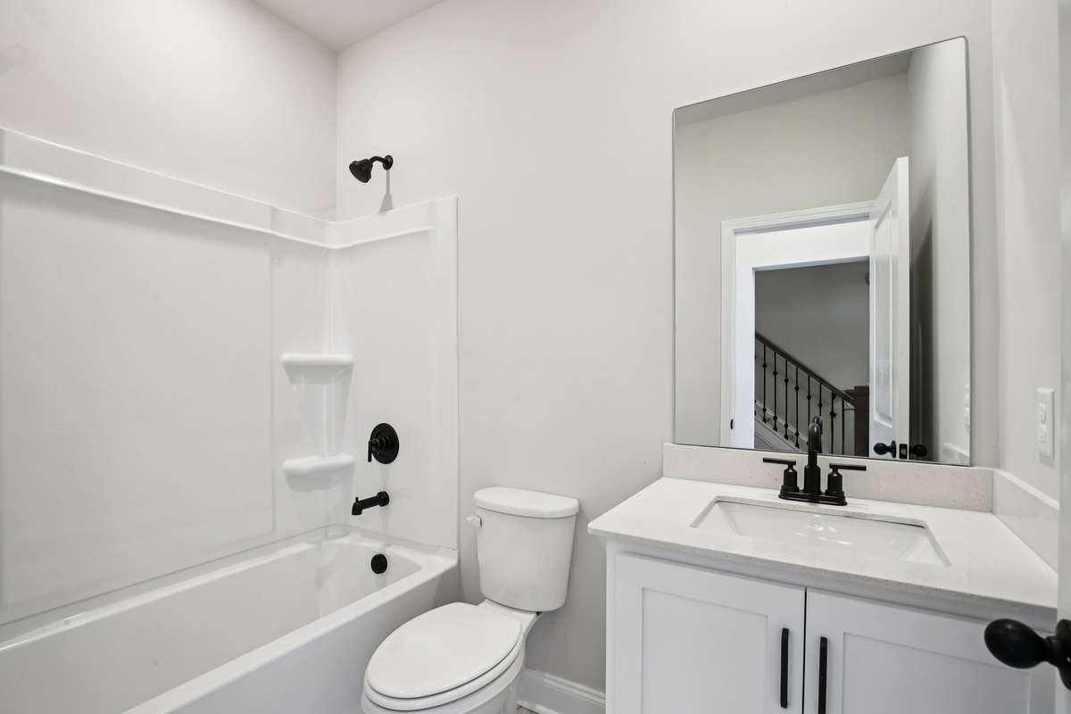 The second bathroom features tile flooring and quartz countertops, combining durability with a clean, modern look.
