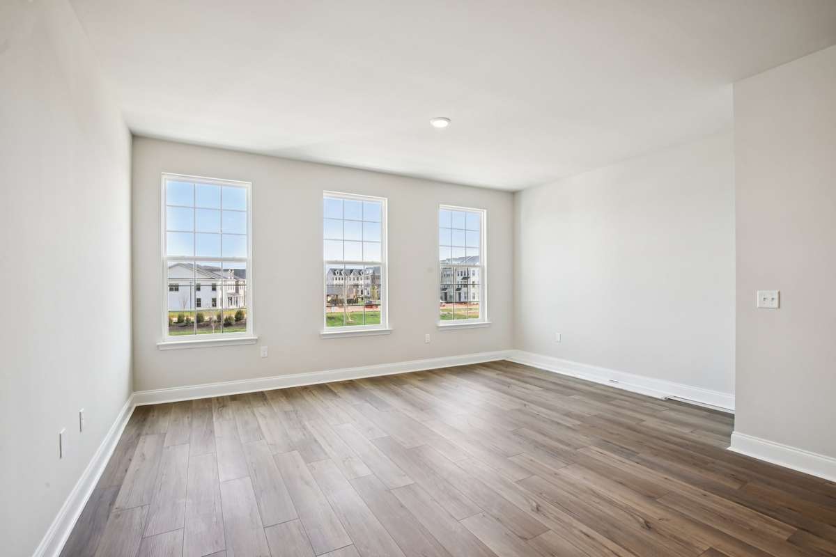 The great room features three large windows that flood the space with natural light, creating a bright and inviting atmosphere.