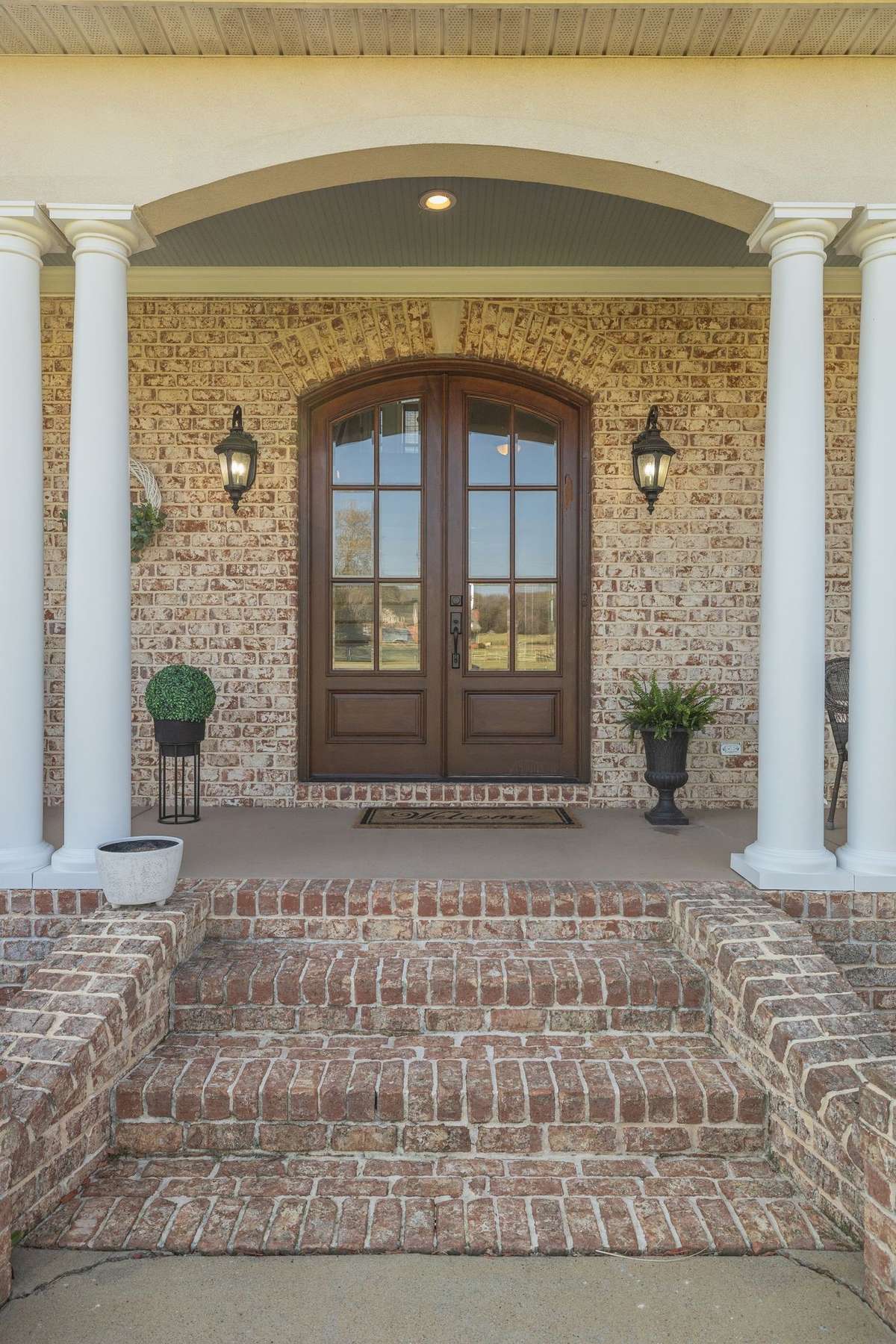 Stunning custom plantation porch setting with solid wood doors