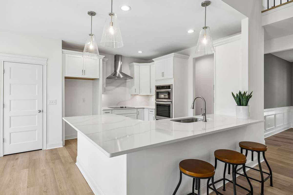 Nice kitchen with pantry, cooktop, double oven, dishwasher and overhang bar ready for several to sit around both sides