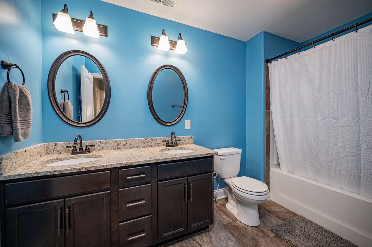 Double vanity and granite counters provide plenty of room to keep daily essentials within reach. Shower/tub combo.