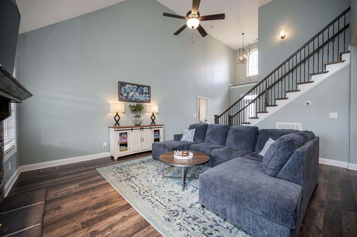 Two-story ceilings and an arched window above give this living area an open, airy feel that makes the space feel larger than its footprint.