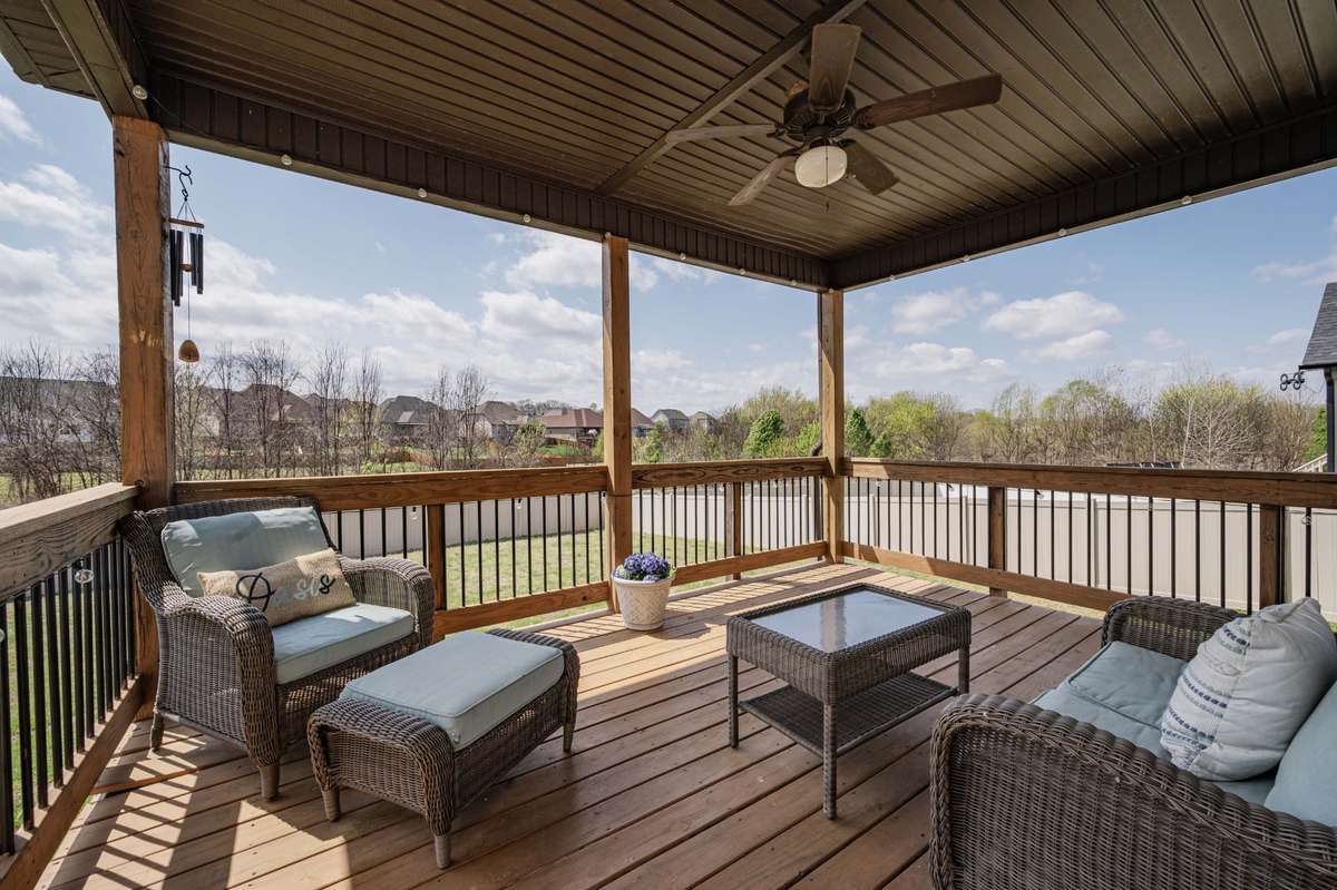 Covered deck with a ceiling fan overlooks the backyard and neighborhood — good spot for morning coffee or evening conversation.