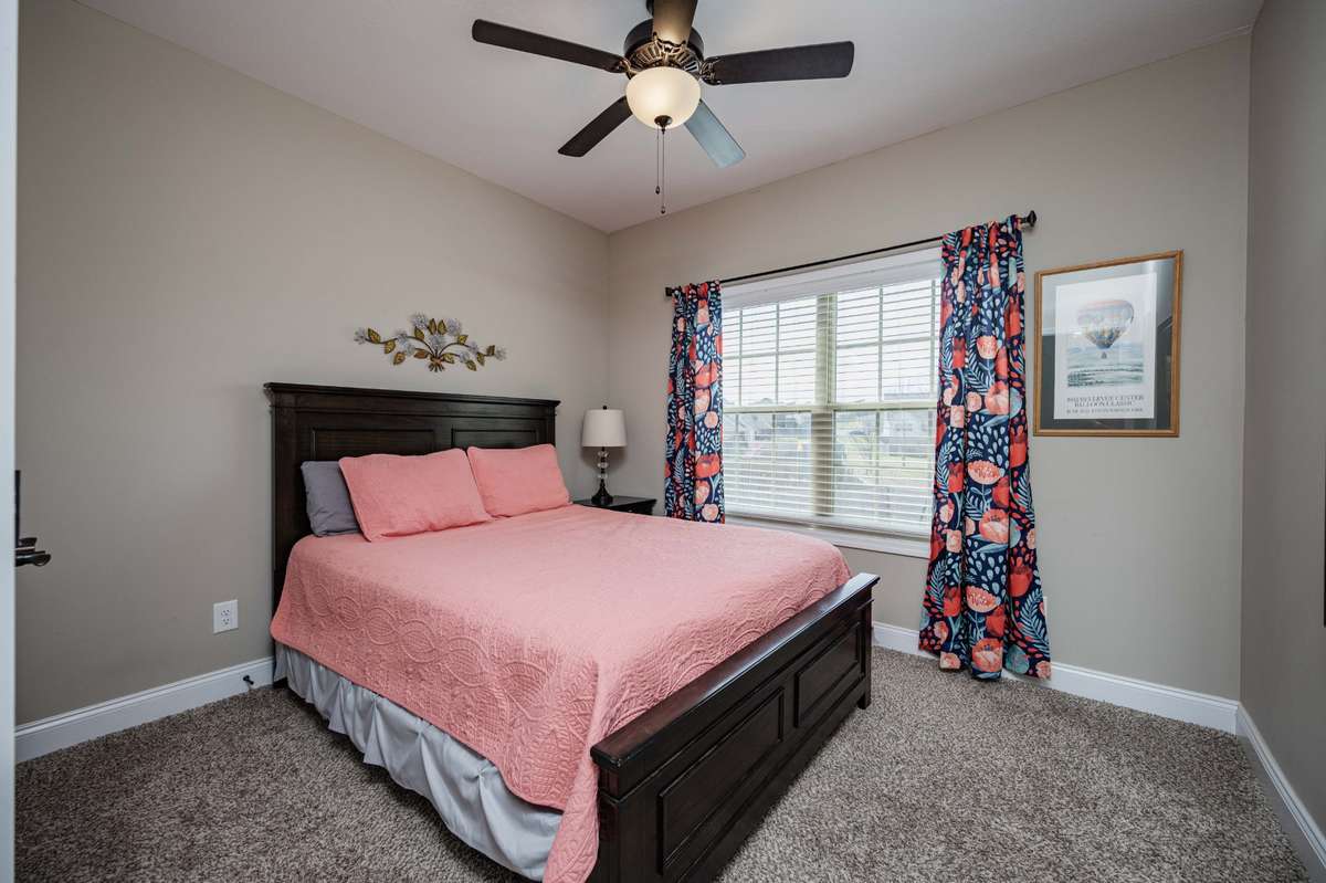 Secondary bedroom with natural light from the wide window, on the main level.