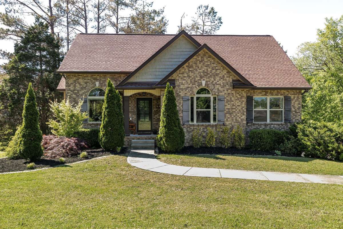 All brick home in the woods on over an acre in the famous Fairview 