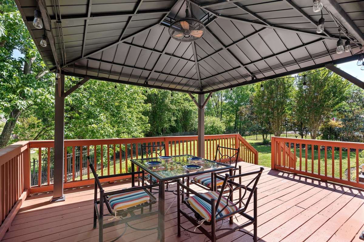 Back deck and gazebo with lights and a fan.