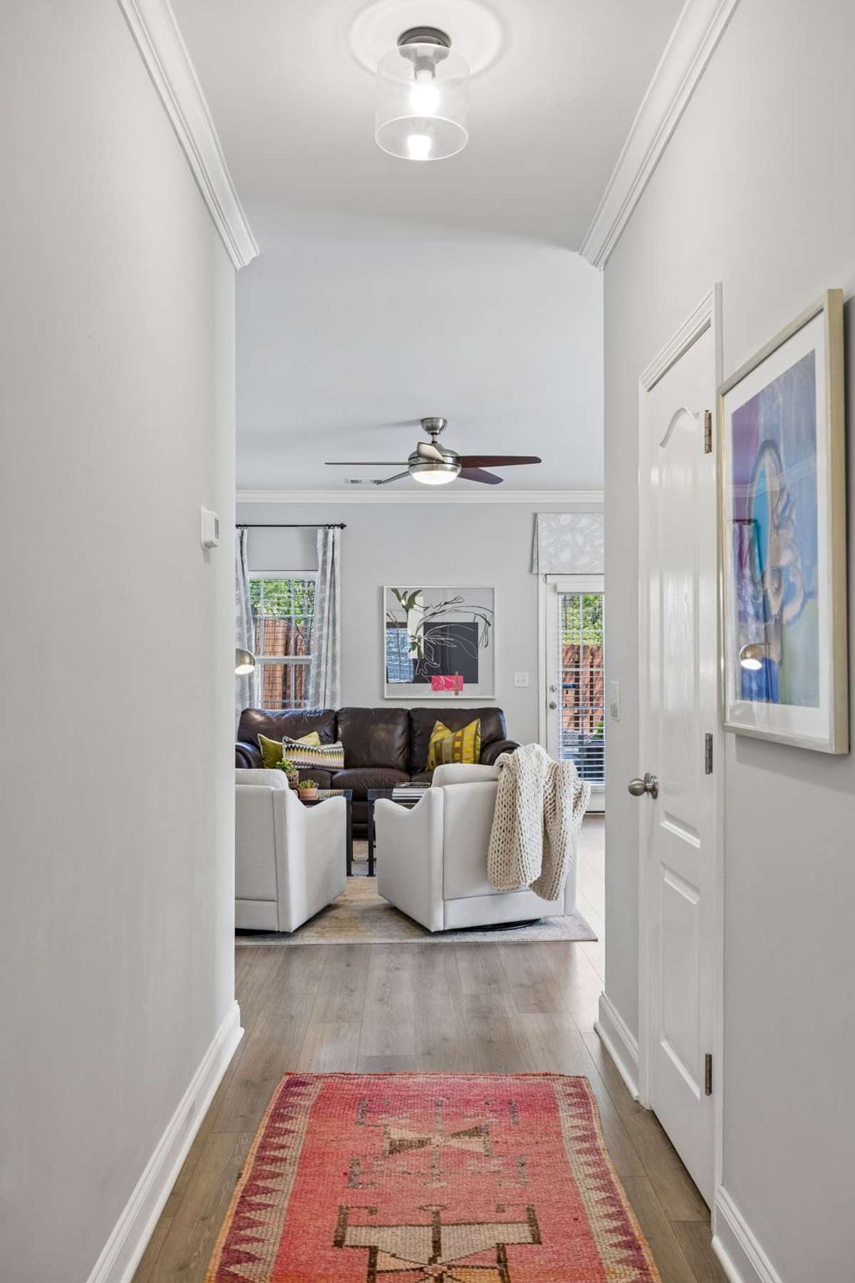 Gleaming luxury flooring, a neutral color palette, and plenty of windows create a bright and welcoming interior,