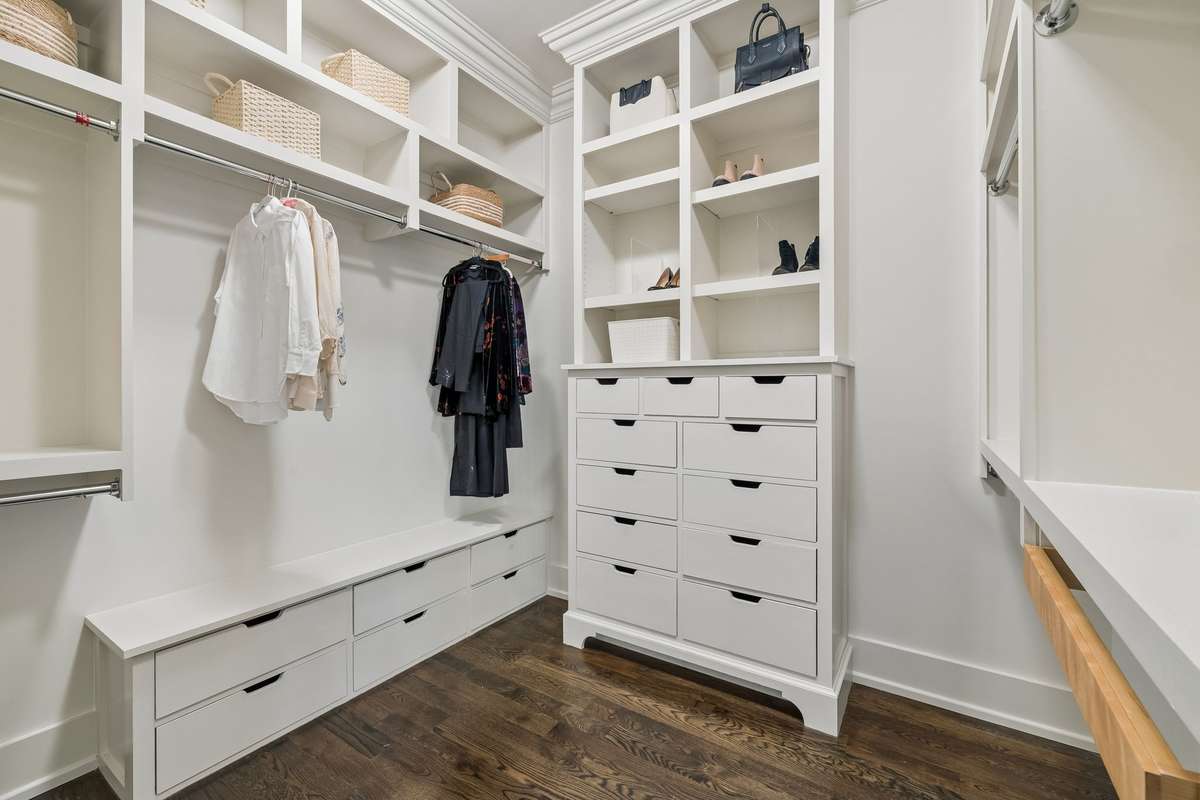 Primary His & Her closets both with custom hardwood built-ins