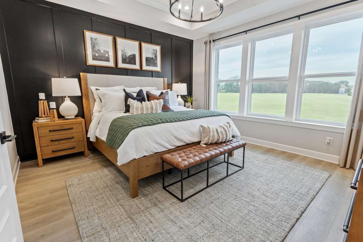 Primary suite on main level features a huge walk-in closet and tons of natural light! King size furnishings shown here.