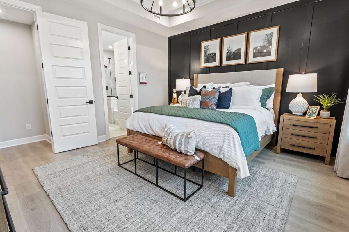 Primary suite on main level features a huge walk-in closet and tons of natural light! King size furnishings shown here.